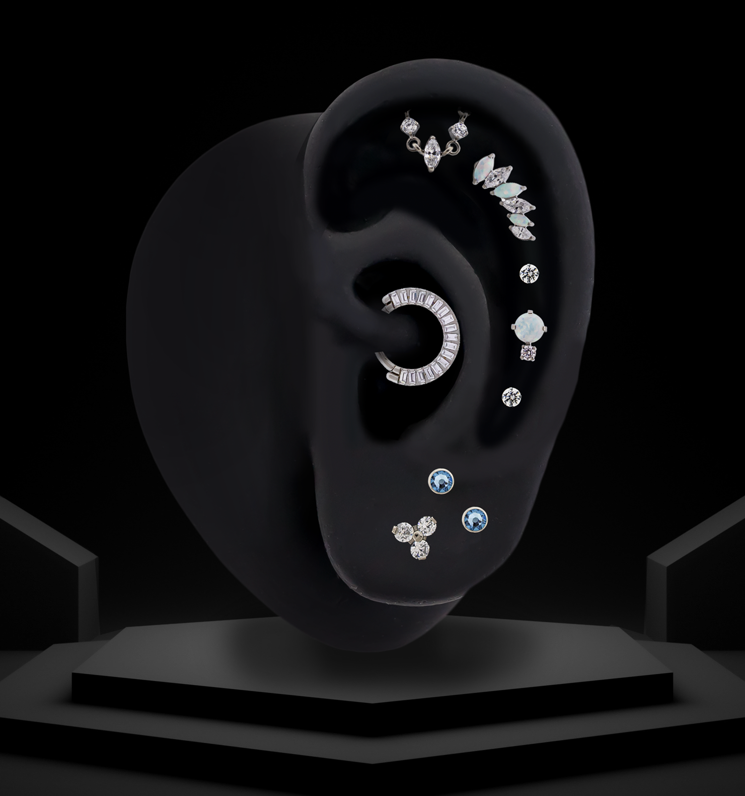 titanium threadless ear curation on a black silicone ear on a luxe black background