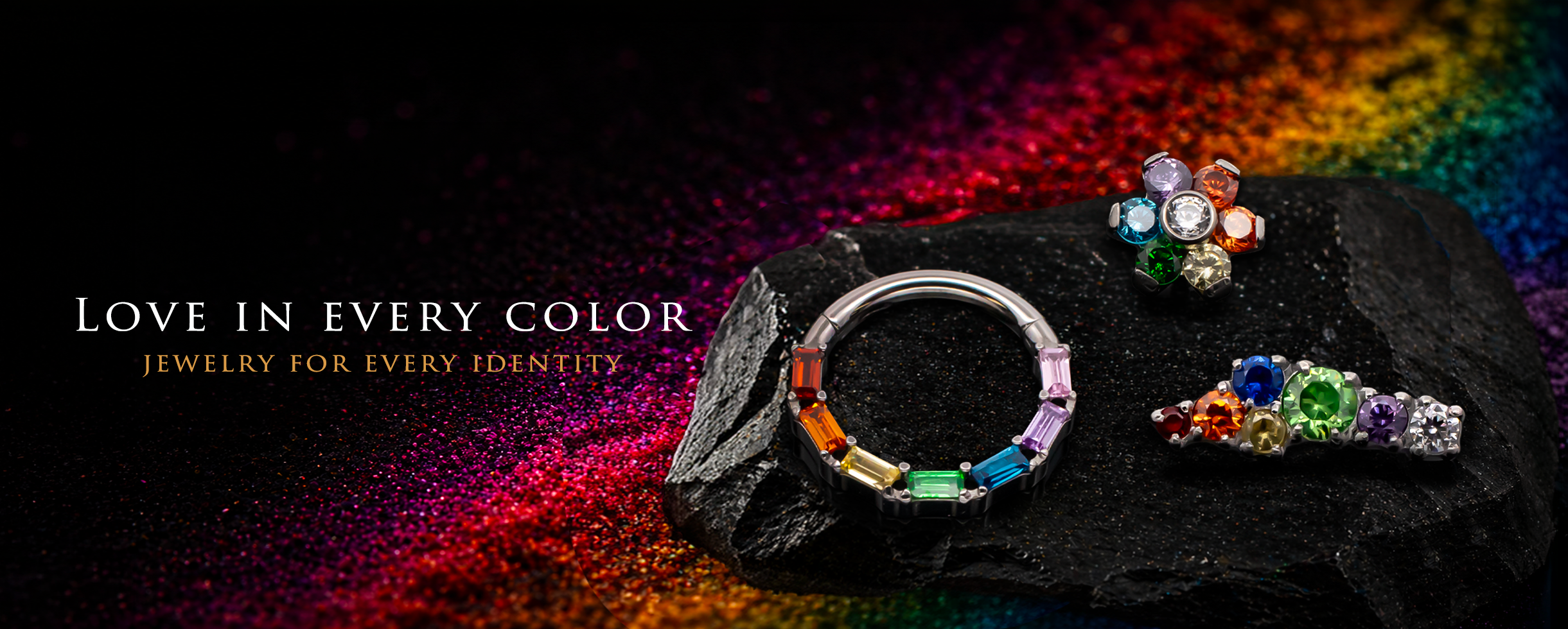 rainbow gem pride theme body jewelry on a black background with a rainbow shadow